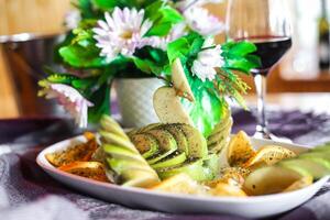 delicioso plato de comida y vaso de vino en mesa foto