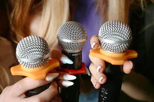 Woman Holding Two Microphones in Her Hands photo