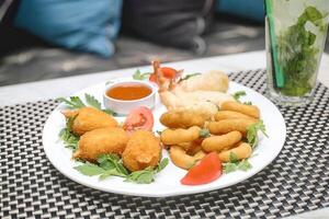 blanco plato con frito comida y taza de salsa foto