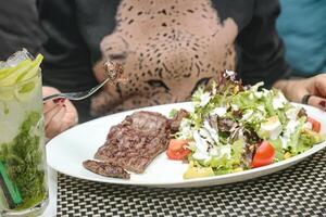 persona sentado a mesa con plato de comida foto