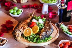 plato de pescado y vegetales en mesa foto