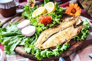 recién cocido pescado y vegetales en mesa foto