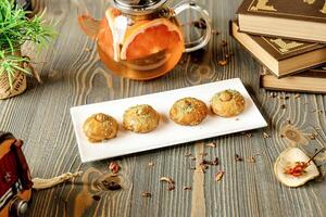 White Plate With Cookies Next to Tea Pot photo