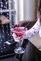 Woman Sitting at Table Holding a Drink photo