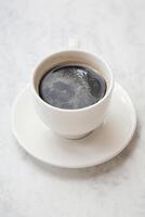 taza de café en platillo en mesa foto