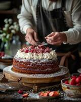 A pastry chef or patissier preparing delicious whole cake photo