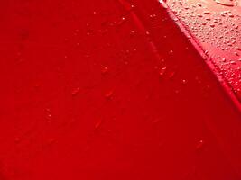rojo paraguas textura con agua gotas para lluvioso día antecedentes. foto