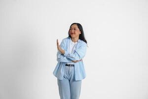 Young Asian woman isolated on white background, looks serious, gesturing decline or NO sign by her hand, frightened and nervous. photo