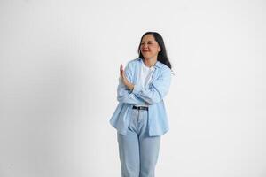 Young Asian woman isolated on white background, looks serious, gesturing decline or NO sign by her hand, frightened and nervous. photo