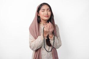 hermosa asiático musulmán mujer Orando a Dios fervorosamente, Orando gesto con manos elevado arriba y participación oración talón. Ramadán y eid Mubarak concepto foto