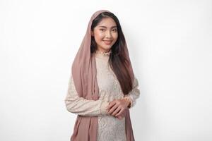 Portrait of beautiful Asian Muslim woman wearing veil hijab giving with formal pose smiling to the camera, standing over isolated white background photo