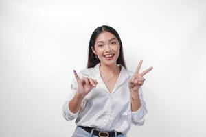 Excited Asian young woman showing little finger dipped in purple ink after voting for Pemilu or Indonesia election and pointing with fingers number one two three, standing on isolated white background photo