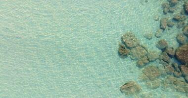 aérien drone vue de clair turquoise mer et vagues plus de le rocheux littoral video
