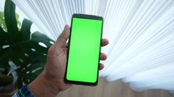detailopname hand- gebruik makend van telefoon tonen groen scherm in leeg kamer video