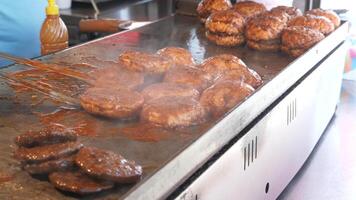 köttbullar rostning i panorera, framställning burger på gata video