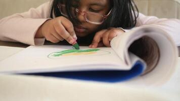 child girl drawing on paper sitting on a chair video