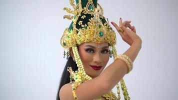 Elegant dancer in traditional Asian costume with intricate headpiece performing cultural dance. video