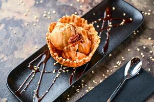 Salted caramel Gelato with ice cream, white chocolate chip, and spoon served in cup isolated on dark background closeup top view of cafe baked dessert food photo