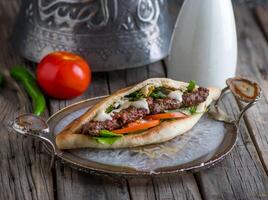 kebab sandwich served in dish side view on wooden table background photo