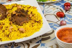 Meat Quzi or Ghozi biryani rice with cashew nut served in dish isolated on table top view of arabic food photo