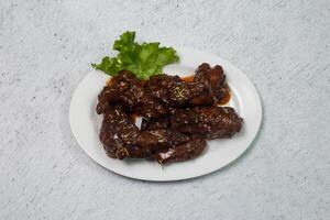 Naga chicken wings served in dish isolated on grey background top view of bangladeshi fastfood photo