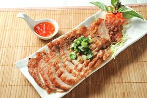 Lemongrass Pork Neck with chilli sauce served in dish isolated of table top view fast food snacks photo