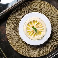 Hummus or hommos, humus with chickpea served in dish isolated on red mat top view on table arabic food photo