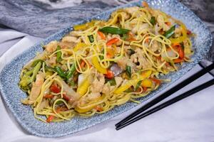 chicken chowmein and vegetable chow mein and chopsticks served in dish isolated on food table top view of middle east spices photo