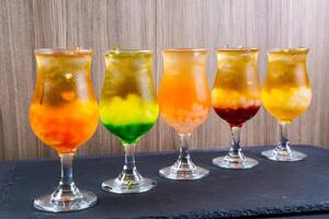 Assortment of Coconut green tea served in glass isolated on background side view of colorful drinks photo