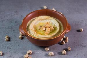 Hummus with chickpeas served in dish isolated on grey background top view of bahrain food photo