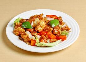 sweet and sour pork served in dish isolated on background top view singapore food photo