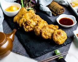 crujiente pollo con queso, chile salsa y palillos servido en tablero aislado en servilleta lado ver de comida rápida aperitivo japonés comida foto