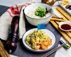 negro trufa mar camarón revuelto huevo pescado udon servido en cuenco con palillos aislado en servilleta lado ver de japonés comida en mesa foto