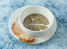 mushroom soup with bread served in bowl isolated on background top view of italian food photo