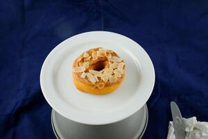 Peanut Butter Donut with knife served in plate Isolated on background side view of baked breakfast food photo