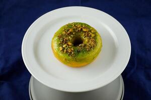 Lemon Pistachio Donut served in plate Isolated on background side view of baked breakfast food photo