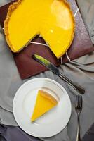 Fresh Lemon Cheesecake slice with fork and knife served in plate isolated on napkin top view cafe bake food photo