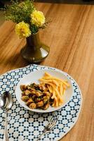 Fried Calamari with french fries, spoon and fork served in dish isolated on table top view of fastfood appetizer photo