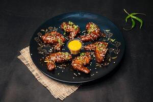 Bbq Chicken Wings with chilli sauce and mayo dip served in dish isolated on napkin dark background top view of indian fastfood photo