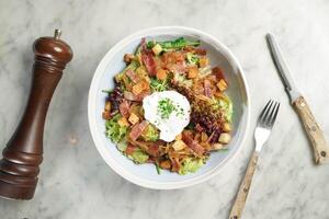 Salade Lyonnaise Bacon Et uf Poche served in dish isolated on marble background top view on hong kong food photo