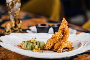 Deep fried Prawn and Soft Shell Fritter served in dish isolated on table side view of arabic appetizer food photo