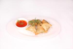 vegetable Samboosa or samosa with sauce served in dish isolated on background side view of arab food photo