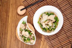 Stir-Fried Snapper Fillets with Gumbo Lily with chopsticks served in dish isolated on mat top view on wooden table Hong Kong food photo