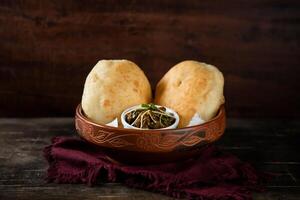 Chole Bhature or channay pathuray and puri served in dish isolated on table top view of indian, bangladeshi and pakistani breakfast food photo