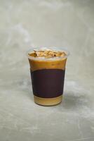 Iced Blended Caramel Coffee served in disposable cup isolated on grey background top view of cafe dessert photo