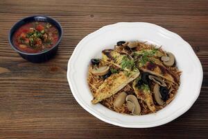 Chicken mushroom noodles with black olive and tomato sauce served in dish isolated on table top view of arabic food photo