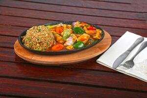 Chicken Breast Sizzling With Brown Fried Rice served in dish isolated on table side view of middle east food photo