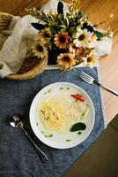 Clear Lemon Chicken Wonton include noodles, spring onion and red pepper served in bowl isolated on napkin top view of chinese soup photo