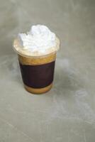 Iced Blended Hazelnut Latte coffee served in disposable cup isolated on grey background top view of cafe dessert photo