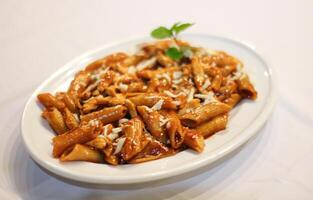 Bbq spicy pasta with white sauce and mint served in dish isolated on table side view of indian spices food photo